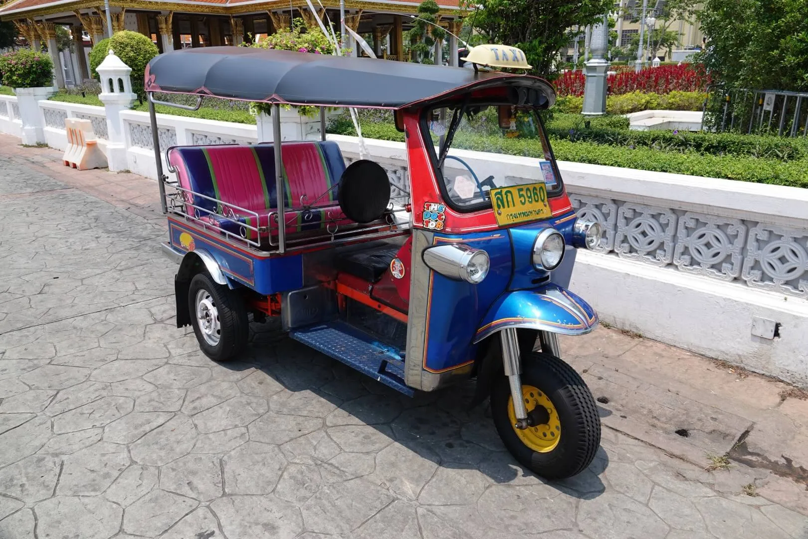 A classic tuk-tuk parked by the roadside.