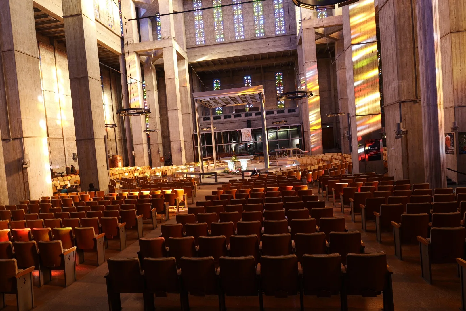 Interior of St. Joseph's Church in Le Havre - colorful light streaming through hundreds of stained-glass windows.