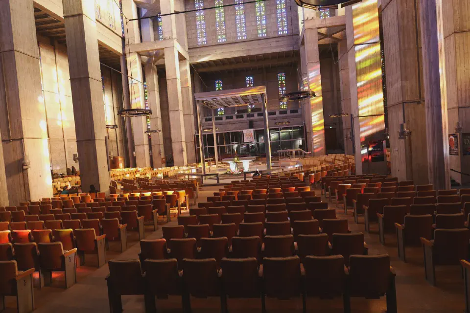 Interior of St. Joseph's Church in Le Havre - colorful light streaming through hundreds of stained-glass windows.