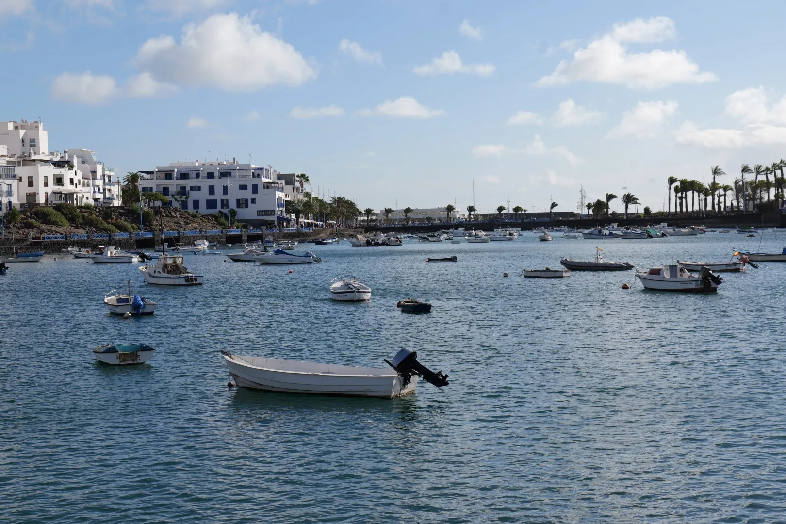 Charco de San Ginés - the picturesque lagoon in the heart of Arrecife, framed by fishing boats, white houses, and palm trees.