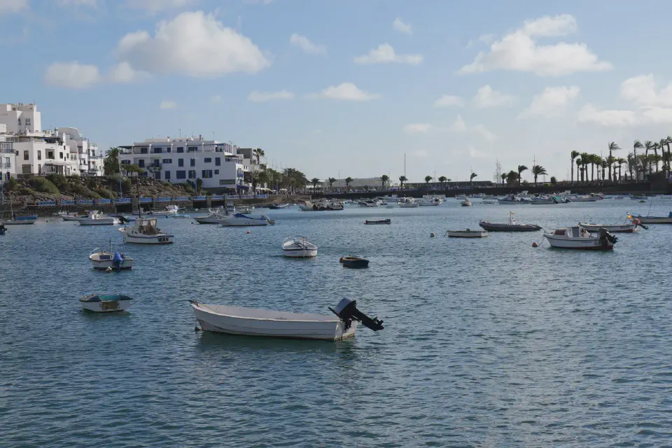 Charco de San Ginés - the picturesque lagoon in the heart of Arrecife, framed by fishing boats, white houses, and palm trees.