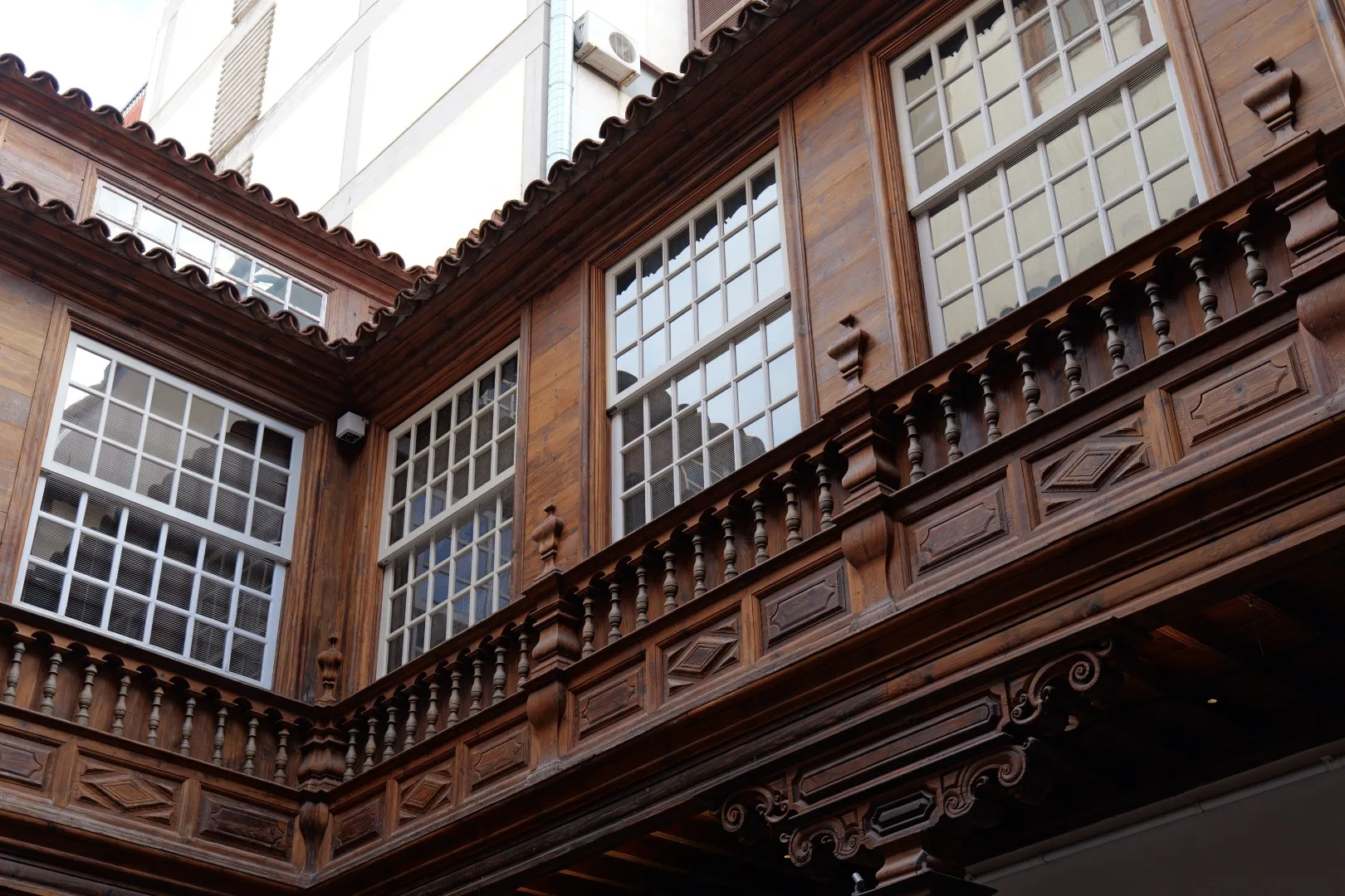 Traditional Canarian wooden architecture in Santa Cruz de Tenerife - intricately carved balconies and window frames in historic style.